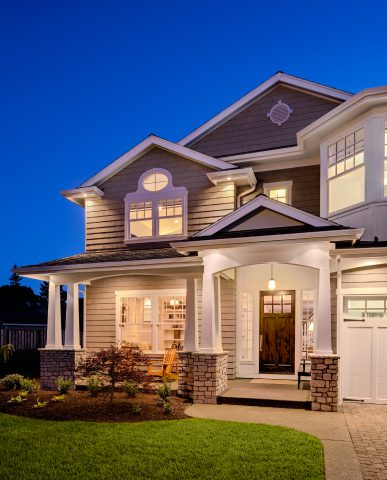 Two-story house with illuminated windows at dusk.