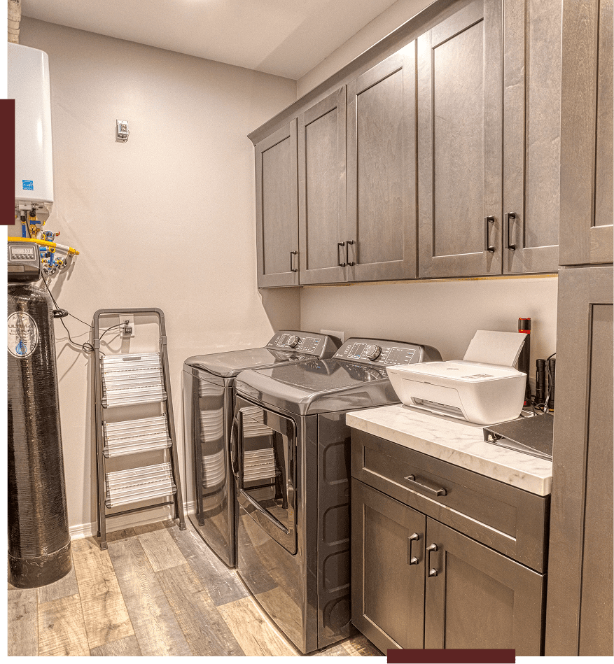 Modern laundry room with appliances and cabinets.